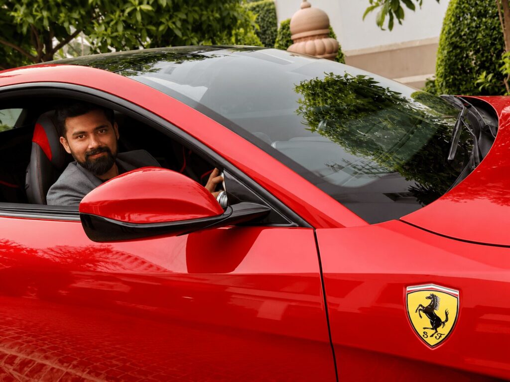 A lifestyle photograph of entrepreneur Vivek Surve with a Ferrari.